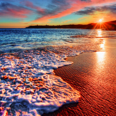 beach sunrise with colorful sand and bright ocean water