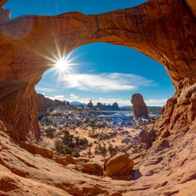 Double Arch in Moab with snow and a sun