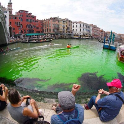Fluorescent green waters below the Rialto Bridge in Venice's Grand Canal