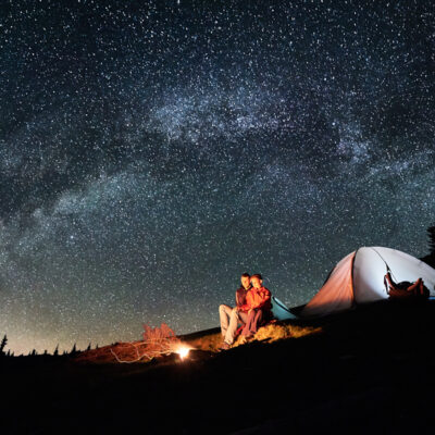 couple camping in tent at night under the stars