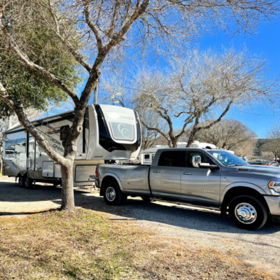 truck hooked up to fifth-wheel camper at pull-through RV site